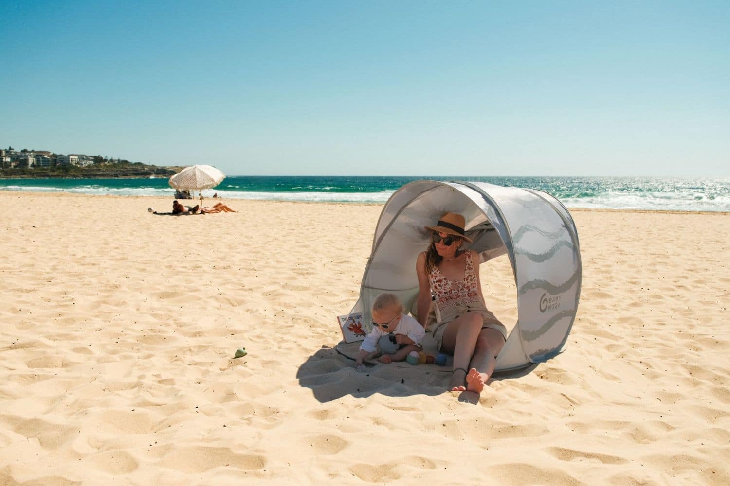 Mère et bébé sous tente sur la plage